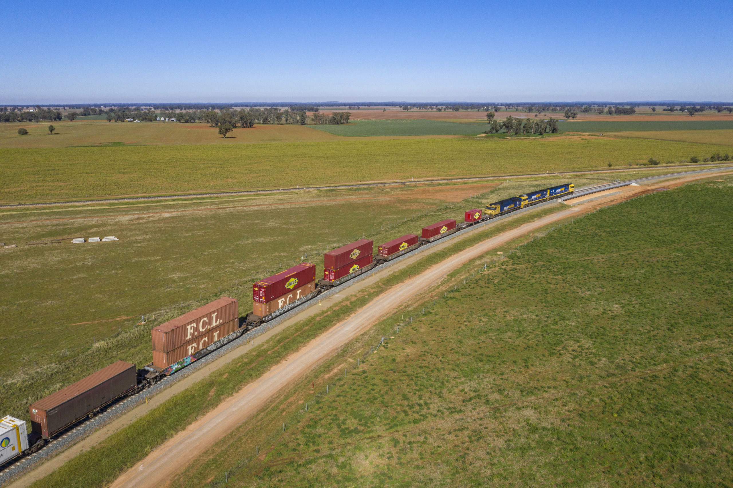 Aerial view of the double-stack container train travels through a rural area near Parkes, New South Wales