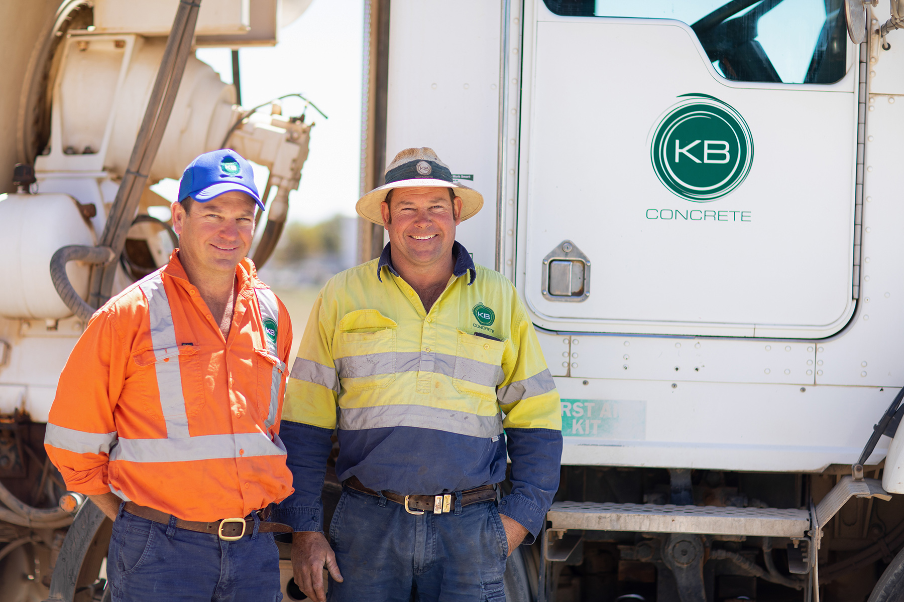 Two workers standing in front of a large truck