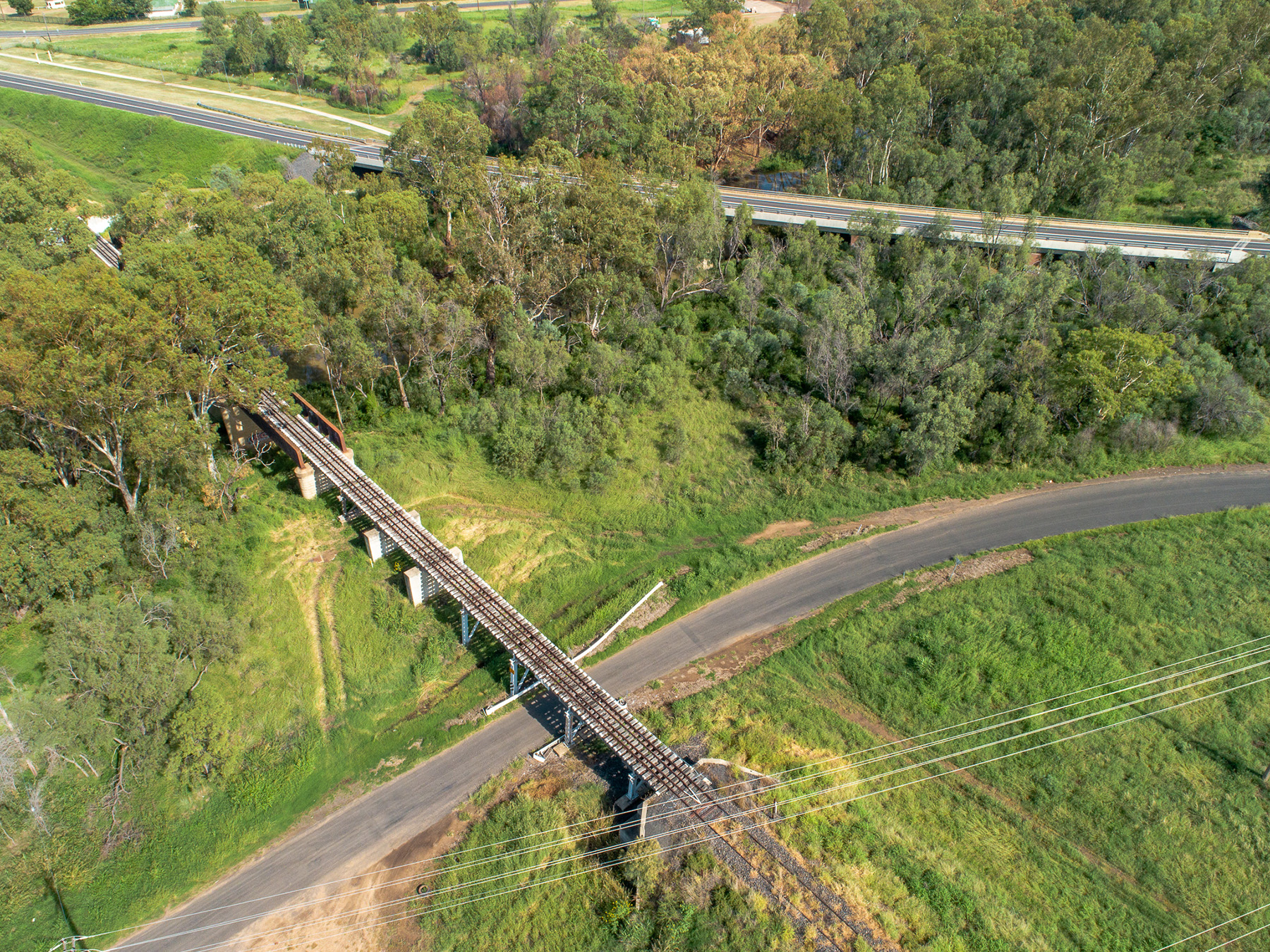 Aerial image of a rail bridge passing over a road.