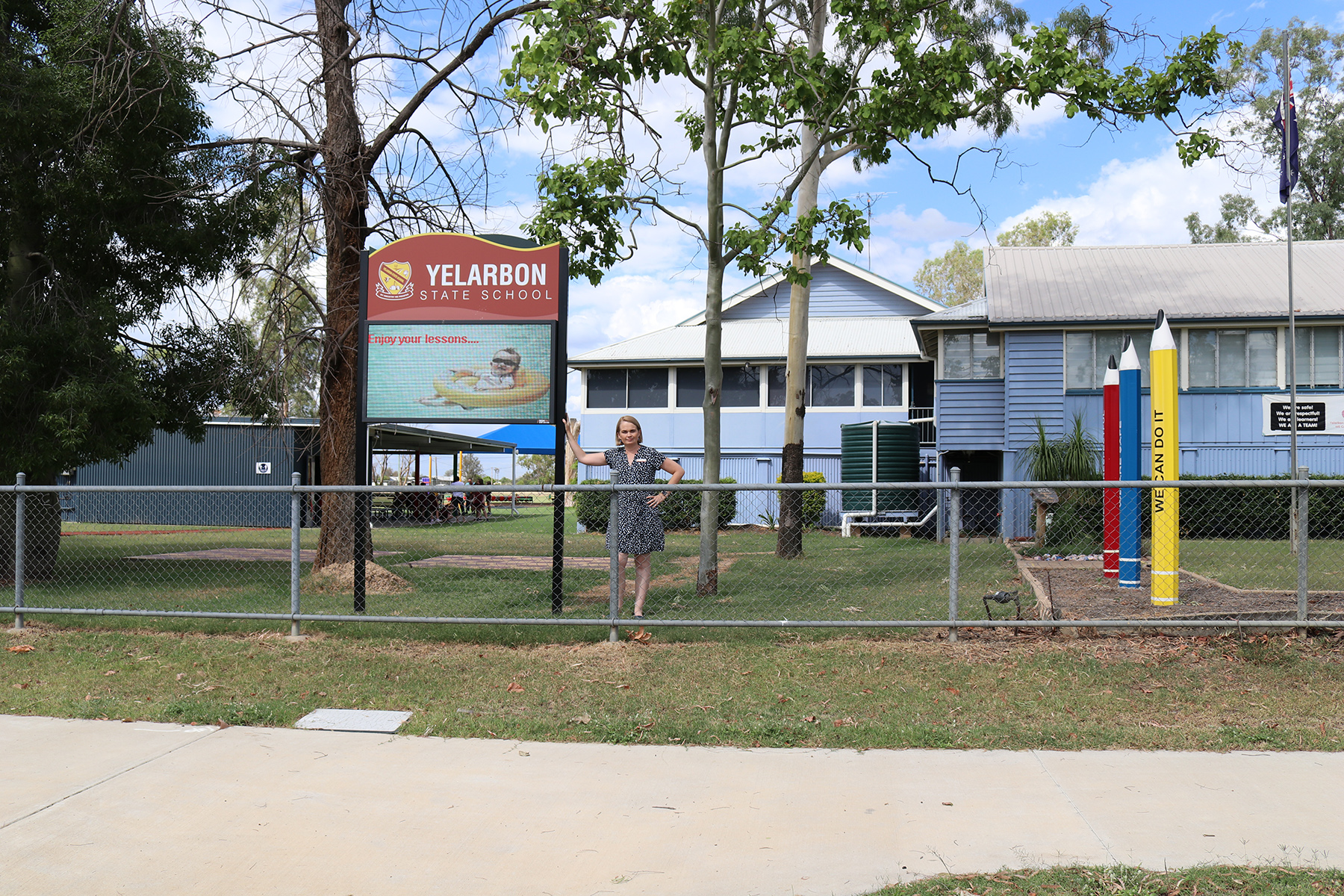 Inland Rail Community Sponsorships and Donations program recipient, Yelarbon State School principal standing under their new digital sign out the front of the school