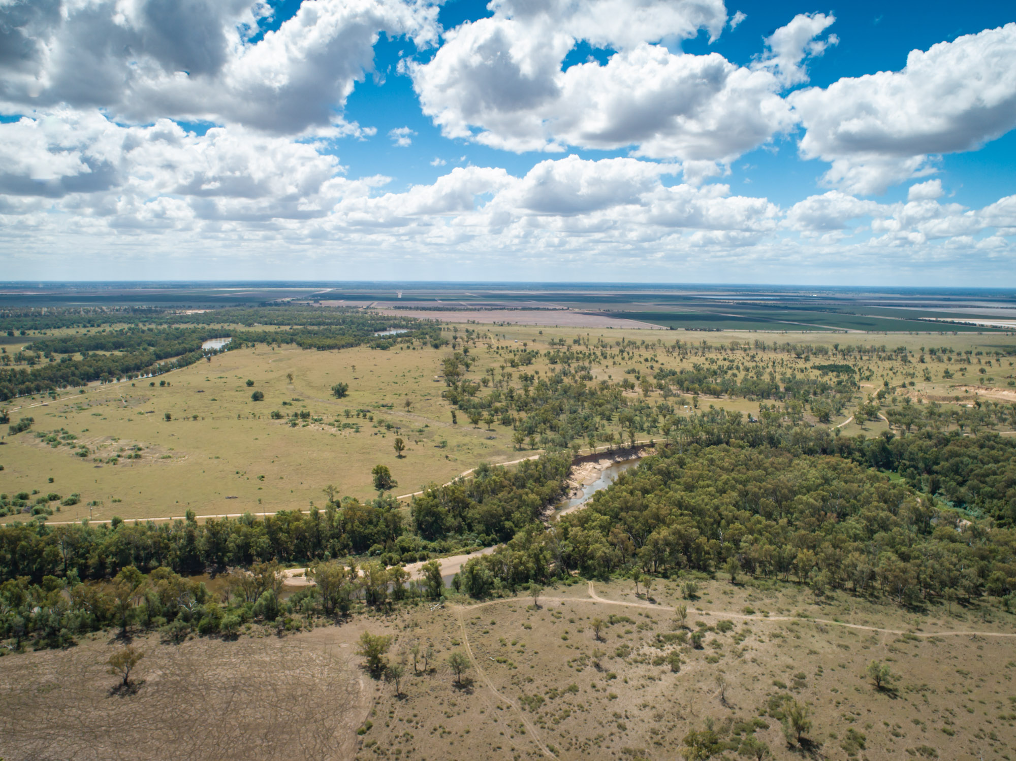 Aerial view of the Macintyre River near Boggabilla showing blue sky and the tree lined river winding through the landscape