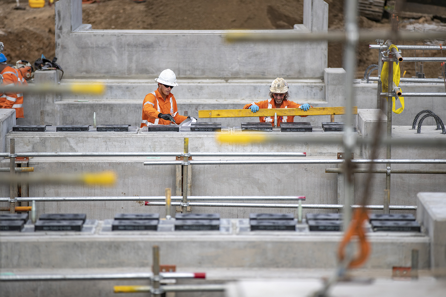 Two rail workers measuring out materials for concrete sleepers as part of the Inland Rail alignment