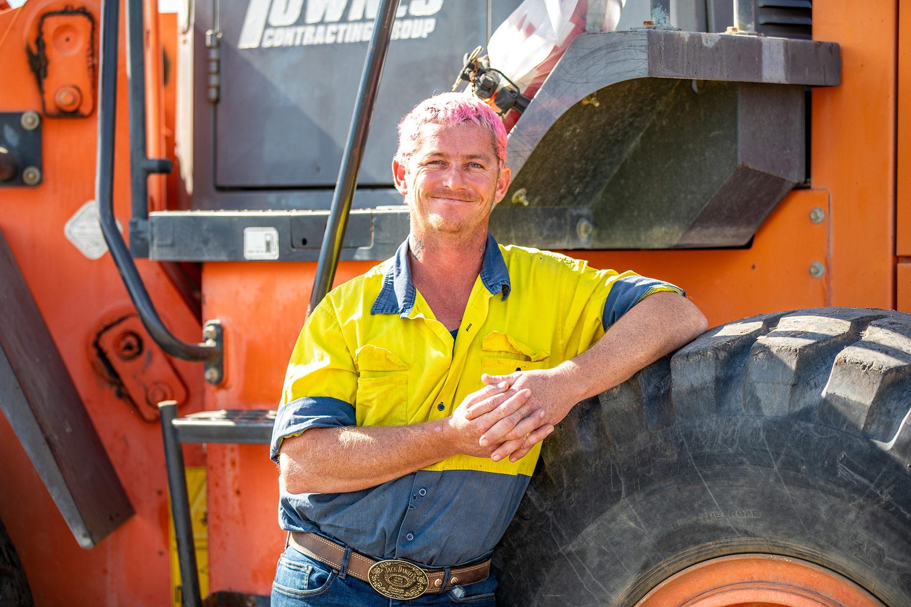 Local civil works subcontractor standing with machinery used to build Inland Rail