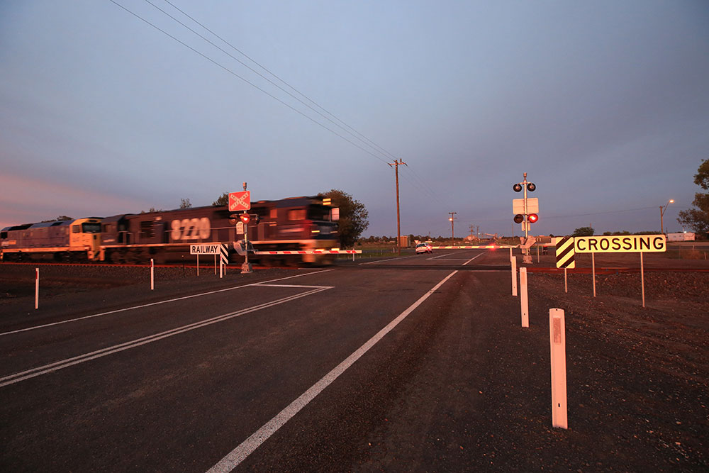 Freight train driving across level crossing in Gurley