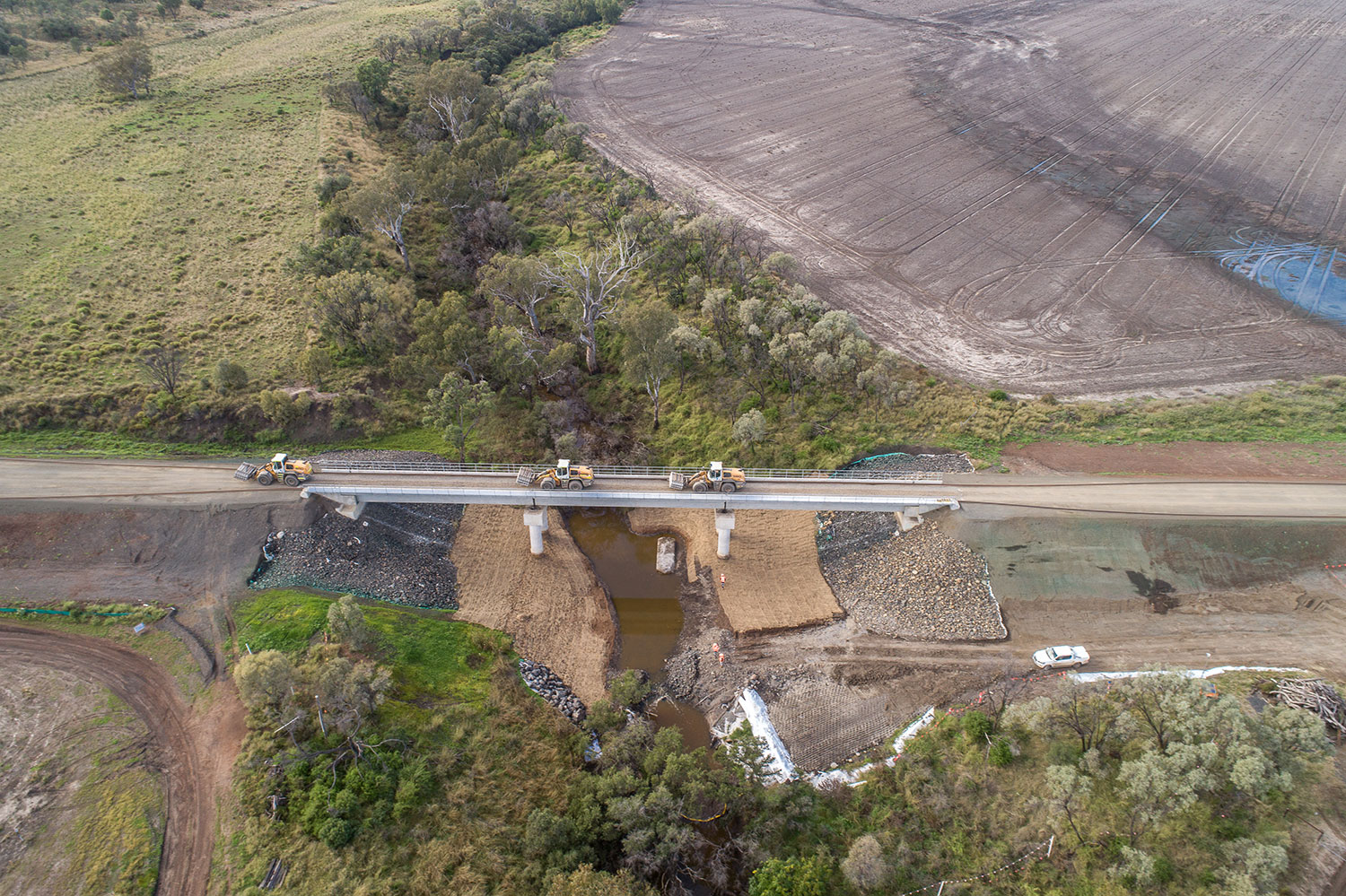 Aerial shot of loaders transporting sleepers across partially finished Croppa Creek Bridge  