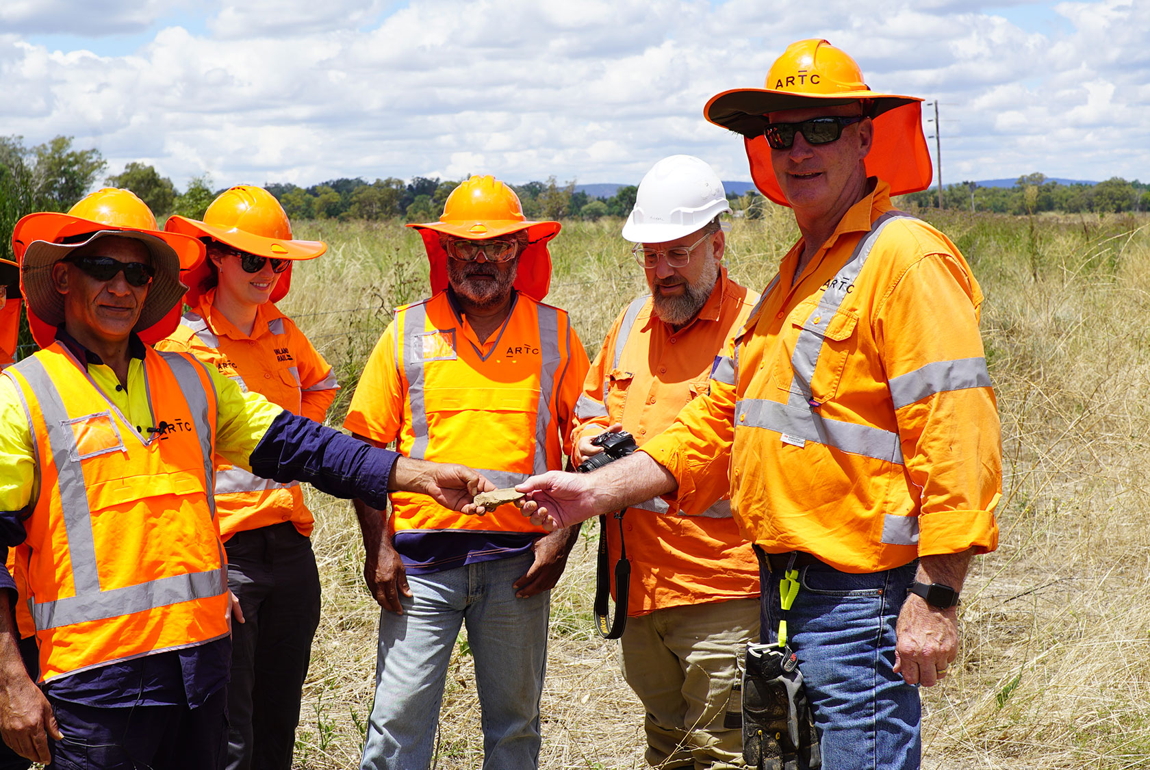 Justin Peckham, Jessica Cuskelly, Terry Roertson, Michael Lever and Steve Smith with one of the artefacts found during construction of the Parkes to Narromine section of Inland Rail at Peak Hill