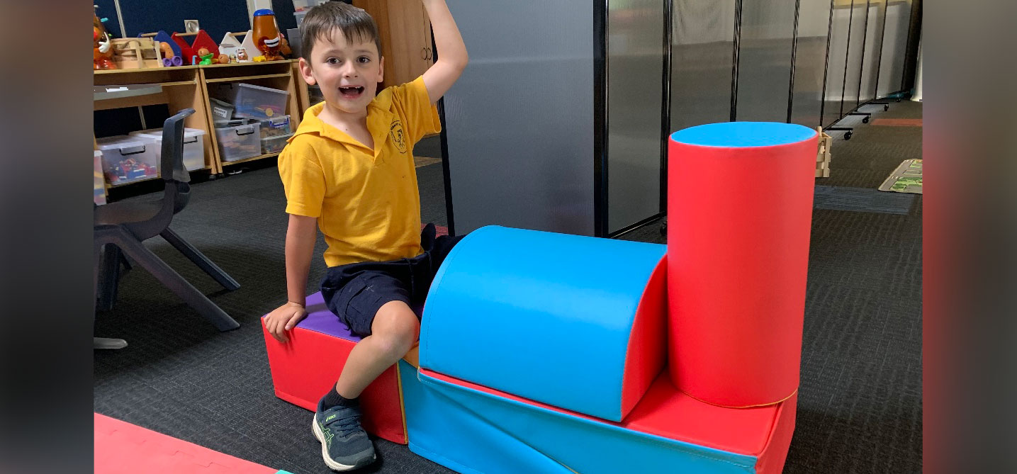Image of Wandong Primary School student on new sensory play blocks built in the shape of a train.