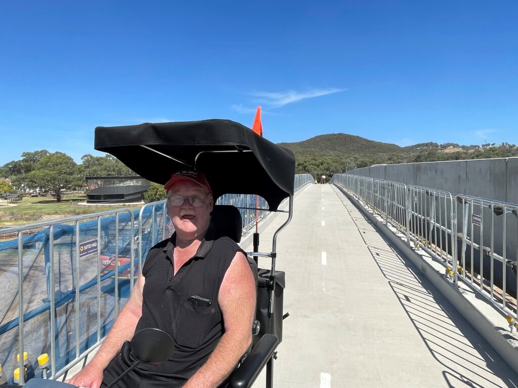 Darren Roberts using his mobility scooter on new footpaths at Beaconsfield Parade bridge, Glenrowan